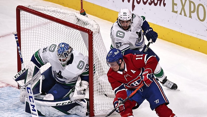 Feb 02, 2021; Montreal, Quebec, CAN; Montreal Canadiens right wing Brendan Gallagher (11) shoots the puck against Vancouver Canucks goaltender Thatcher Demko (35) as defenseman Jalen Chatfield (63) defends  defends during the second period at Bell Centre. Mandatory Credit: Jean-Yves Ahern-USA TODAY Sports