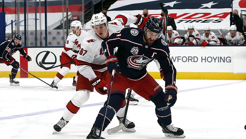 Feb 8, 2021; Columbus, Ohio, USA; Columbus Blue Jackets left wing Nick Foligno (71) settles down rolling puck as Carolina Hurricanes center Morgan Geekie (67) trails the playduring the first period at Nationwide Arena. Mandatory Credit: Russell LaBounty-USA TODAY Sports