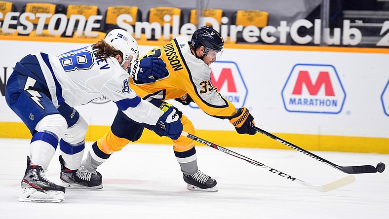 Feb 8, 2021; Nashville, Tennessee, USA; Nashville Predators right wing Viktor Arvidsson (33) attempts a shot with pressure from Tampa Bay Lightning defenseman Mikhail Sergachev (98) during the first period at Bridgestone Arena. Mandatory Credit: Christopher Hanewinckel-USA TODAY Sports