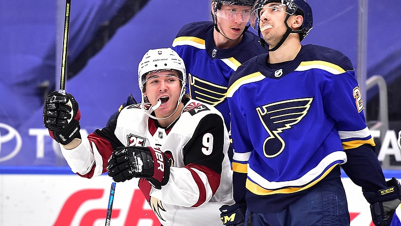 Feb 8, 2021; St. Louis, Missouri, USA;  Arizona Coyotes right wing Clayton Keller (9) celebrates after assisting on a goal as St. Louis Blues center Jordan Kyrou (25) reacts at Enterprise Center. Mandatory Credit: Jeff Curry-USA TODAY Sports