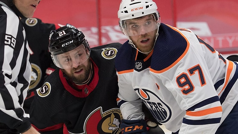 Feb 9, 2021; Ottawa, Ontario, CAN; Ottawa Senators center Derek Stepan (21) and Edmonton Oilers center Connor McDavid (97) follow the puck after a face off in the first period at the Canadian Tire Centre. Mandatory Credit: Marc DesRosiers-USA TODAY Sports