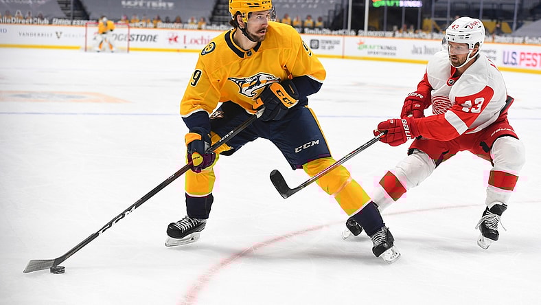 Feb 11, 2021; Nashville, Tennessee, USA; Nashville Predators left wing Filip Forsberg (9) looks to pass the puck as he is defended by Detroit Red Wings left wing Darren Helm (43) during the first period at Bridgestone Arena. Mandatory Credit: Christopher Hanewinckel-USA TODAY Sports
