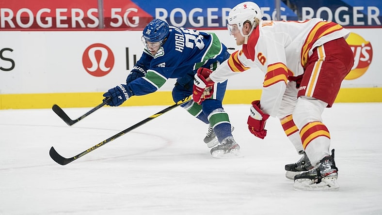 Feb 11, 2021; Vancouver, British Columbia, CAN; Vancouver Canucks forward Nils Hoglander (36) shoots past Calgary Flames defenseman Juuso Valimaki (6) in the first period at Rogers Arena. Mandatory Credit: Bob Frid-USA TODAY Sports