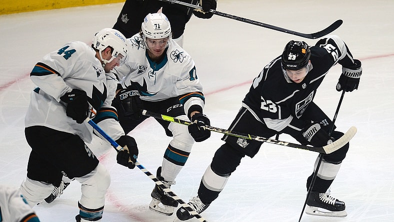 Feb 11, 2021; Los Angeles, California, USA; Los Angeles Kings right wing Dustin Brown (23) plays for the puck against San Jose Sharks defenseman Marc-Edouard Vlasic (44) and defenseman Nikolai Knyzhov (71) during the first period at Staples Center. Mandatory Credit: Gary A. Vasquez-USA TODAY Sports