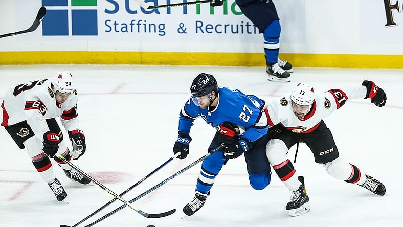 Feb 13, 2021; Winnipeg, Manitoba, CAN;  Winnipeg Jets forward Nikolaj Ehlers (27) battles Ottawa Senators forward Nick Paul (13) and forward Evgeni Dadonov (63) for the puck during the first period at Bell MTS Place. Mandatory Credit: Terrence Lee-USA TODAY Sports
