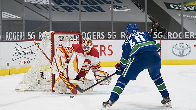 Feb 13, 2021; Vancouver, British Columbia, CAN; Calgary Flames goalie Jacob Markstrom (25) makes a save against Vancouver Canucks forward Elias Pettersson (40) in the first period at Rogers Arena. Mandatory Credit: Bob Frid-USA TODAY Sports