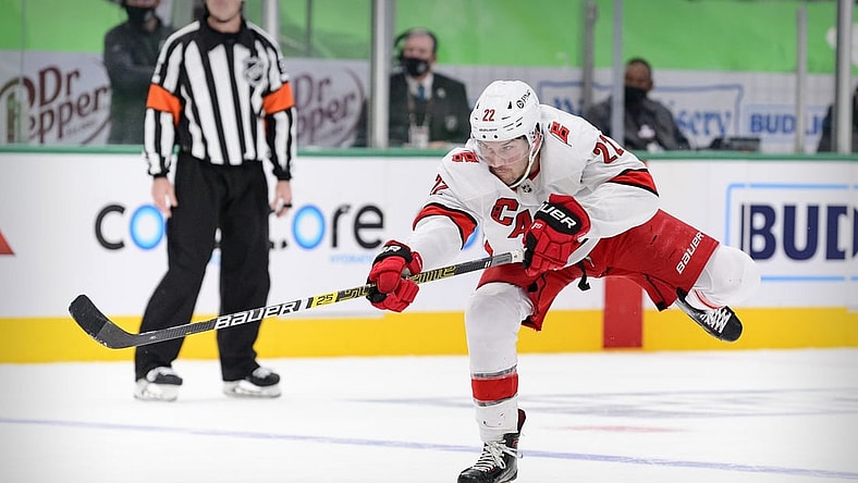 Feb 13, 2021; Dallas, Texas, USA; Carolina Hurricanes defenseman Brett Pesce (22) shoots the puck in the Dallas Stars zone during the third period at the American Airlines Center. Mandatory Credit: Jerome Miron-USA TODAY Sports