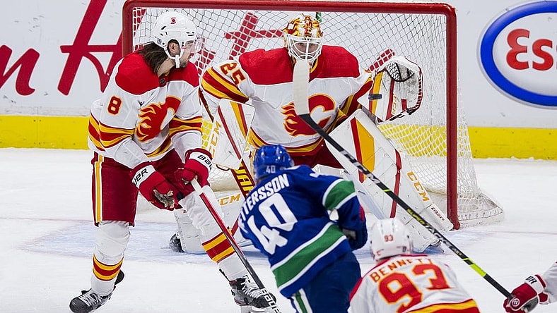 Feb 13, 2021; Vancouver, British Columbia, CAN; Calgary Flames goalie Jacob Markstrom (25) makes a save against Vancouver Canucks forward Elias Pettersson (40) as Calgary defenseman Christopher Tanev (8) looks on in the third period at Rogers Arena. Vancouver won 3-1. Mandatory Credit: Bob Frid-USA TODAY Sports