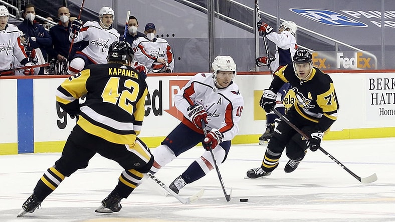 Feb 14, 2021; Pittsburgh, Pennsylvania, USA;  Washington Capitals center Nicklas Backstrom (19) carries the puck between Pittsburgh Penguins right wing Kasperi Kapanen (42) and center Evgeni Malkin (71) during the first period at PPG Paints Arena. Mandatory Credit: Charles LeClaire-USA TODAY Sports