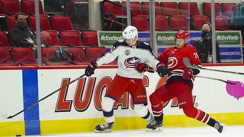 Feb 15, 2021; Raleigh, North Carolina, USA; Columbus Blue Jackets center Alexandre Texier (42) and Carolina Hurricanes right wing Sebastian Aho (20) chase after the puck during the first period at PNC Arena. Mandatory Credit: James Guillory-USA TODAY Sports