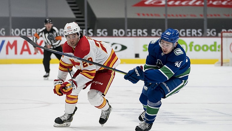 Feb 15, 2021; Vancouver, British Columbia, CAN; Vancouver Canucks defenseman Quinn Hughes (43) checks Calgary Flames forward Dillon Dube (29) in the first period at Rogers Arena. Mandatory Credit: Bob Frid-USA TODAY Sports