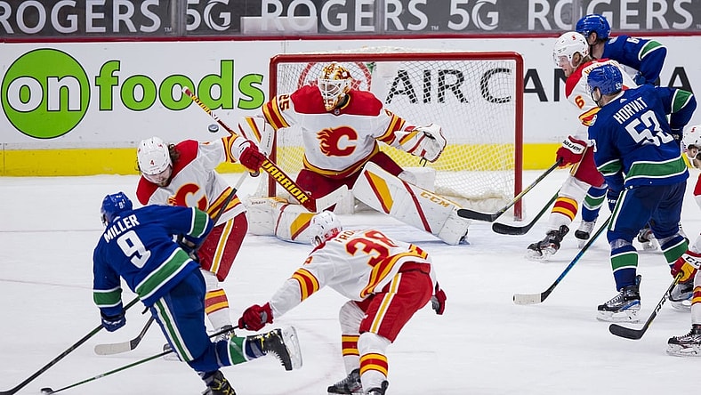 Feb 15, 2021; Vancouver, British Columbia, CAN; Calgary Flames goalie Jacob Markstrom (25) makes a save on shot form Vancouver Canucks forward J.T. Miller (9) in the third period period at Rogers Arena. Flames won 4-3 in Overtime. Mandatory Credit: Bob Frid-USA TODAY Sports