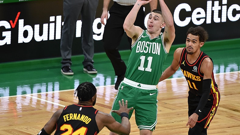 Feb 17, 2021; Boston, Massachusetts, USA; Boston Celtics guard Payton Pritchard (11) shoots the ball while defended by Atlanta Hawks forward Bruno Fernando (24) and guard Trae Young (11) during the first half at TD Garden. Mandatory Credit: Bob DeChiara-USA TODAY Sports