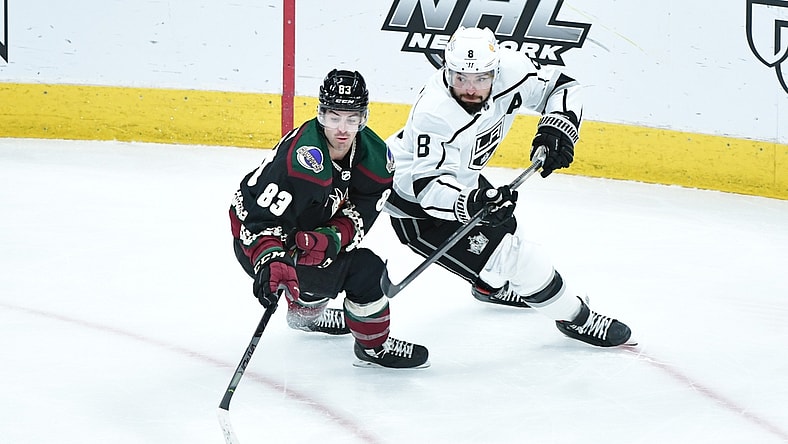 Feb 18, 2021; Glendale, Arizona, USA; Arizona Coyotes right wing Conor Garland (83) steals the puck from Los Angeles Kings defenseman Drew Doughty (8) during the first period at Gila River Arena. Mandatory Credit: Matt Kartozian-USA TODAY Sports