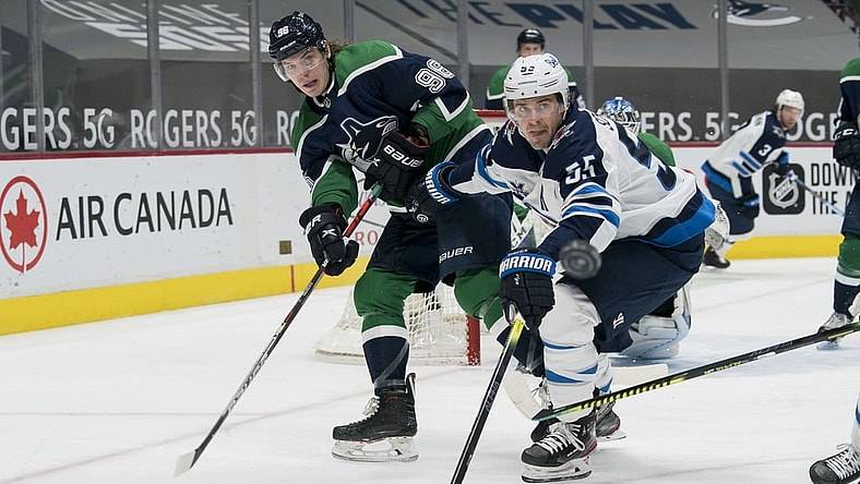 Feb 19, 2021; Vancouver, British Columbia, CAN; Winnipeg Jets forward Mark Scheifele (55) checks Vancouver Canucks forward Adam Gaudette (96) in the second period at Rogers Arena. Mandatory Credit: Bob Frid-USA TODAY Sports