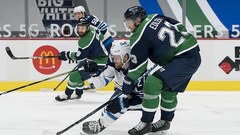 Feb 19, 2021; Vancouver, British Columbia, CAN; Vancouver Canucks defenseman Alexander Edler (23) checks Winnipeg Jets forward Nikolaj Ehlers (27) in the second period at Rogers Arena. Mandatory Credit: Bob Frid-USA TODAY Sports