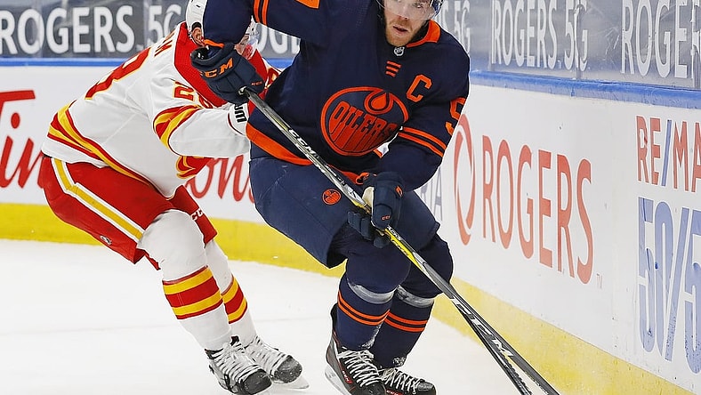Feb 20, 2021; Edmonton, Alberta, CAN; Edmonton Oilers forward Connor McDavid (97) moves the puck past Calgary Flames forward Elias Lindholm (28) during the first period at Rogers Place. Mandatory Credit: Perry Nelson-USA TODAY Sports