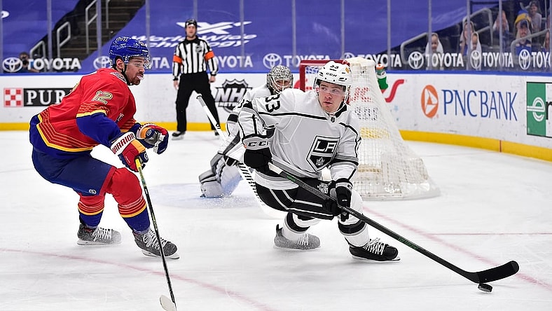 Feb 22, 2021; St. Louis, Missouri, USA;  Los Angeles Kings defenseman Tobias Bjornfot (33) handles the puck as St. Louis Blues left wing Zach Michael Sanford (12) defends during the first period at Enterprise Center. Mandatory Credit: Jeff Curry-USA TODAY Sports