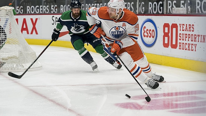 Feb 23, 2021; Vancouver, British Columbia, CAN; Vancouver Canucks defenseman Jordie Benn (8) defends Edmonton Oilers forward Leon Draisaitl (29) in the first period at Rogers Arena. Mandatory Credit: Bob Frid-USA TODAY Sports