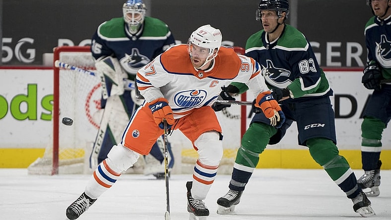 Feb 23, 2021; Vancouver, British Columbia, CAN; Edmonton Oilers forward Connor McDavid (97) skates after the loose puck against the Vancouver Canucks  in the second period at Rogers Arena. Mandatory Credit: Bob Frid-USA TODAY Sports