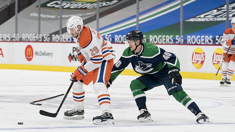 Feb 23, 2021; Vancouver, British Columbia, CAN; Edmonton Oilers forward Leon Draisaitl (29) moves the puck against Vancouver Canucks forward Elias Pettersson (40) in the third period at Rogers Arena. Oilers won 4-3. Mandatory Credit: Bob Frid-USA TODAY Sports