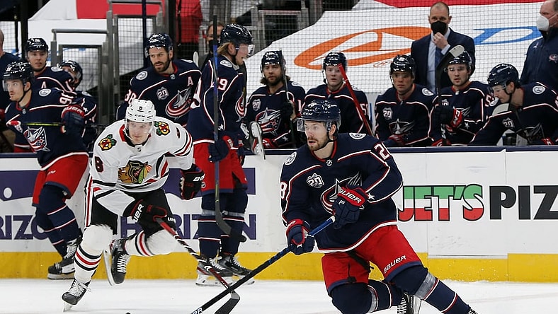 Feb 25, 2021; Columbus, Ohio, USA; Columbus Blue Jackets right wing Oliver Bjorkstrand (28) grabs a loose puck against the Chicago Blackhawks during the first period at Nationwide Arena. Mandatory Credit: Russell LaBounty-USA TODAY Sports