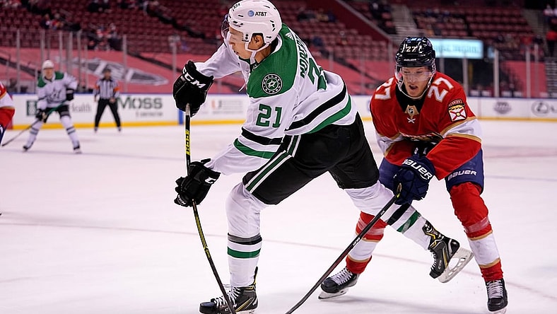 Feb 25, 2021; Sunrise, Florida, USA; Dallas Stars left wing Jason Robertson (21) shoots the puck in front of Florida Panthers center Eetu Luostarinen (27) during the first period at BB&T Center. Mandatory Credit: Jasen Vinlove-USA TODAY Sports