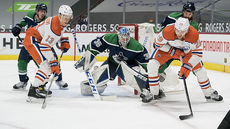 Feb 25, 2021; Vancouver, British Columbia, CAN; Vancouver Canucks goalie Thatcher Demko (35) makes a save on Edmonton Oilers forward Leon Draisaitl (29) as Edmonton Oilers forward Jesse Puljujarvi (13) and Vancouver Canucks defenseman Jordie Benn (8) look on in the first period at Rogers Arena. Mandatory Credit: Bob Frid-USA TODAY Sports