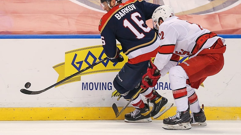 Feb 27, 2021; Sunrise, Florida, USA; Florida Panthers center Aleksander Barkov (16) controls the puck around Carolina Hurricanes defenseman Brett Pesce (22) during the second period at BB&T Center. Mandatory Credit: Sam Navarro-USA TODAY Sports