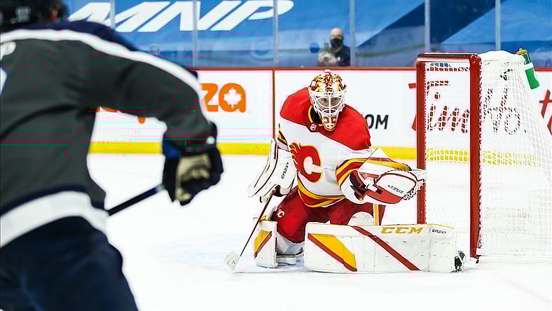 Feb 4, 2021; Winnipeg, Manitoba, CAN; Calgary Flames goalie Jacob Markstrom (25) makes a save on a shot by Winnipeg Jets forward Andrew Copp (9) during the second period at Bell MTS Place. Mandatory Credit: Terrence Lee-USA TODAY Sports