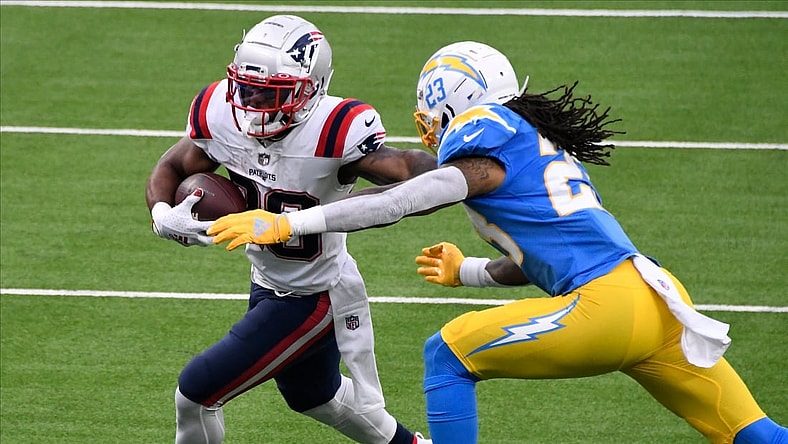 Dec 6, 2020; Inglewood, California, USA; New England Patriots running back James White (28) tries to break free from Los Angeles Chargers free safety Nasir Adderley (24) during the second quarter at SoFi Stadium. Mandatory Credit: Robert Hanashiro-USA TODAY Sports