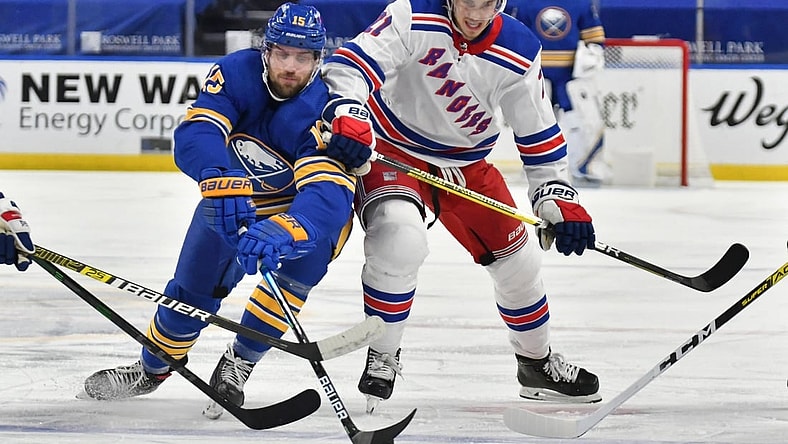 Jan 28, 2021; Buffalo, New York, USA; Buffalo Sabres center Riley Sheahan (15) and New York Rangers center Brett Howden (21) reach for the puck in the second period at KeyBank Center. Mandatory Credit: Mark Konezny-USA TODAY Sports
