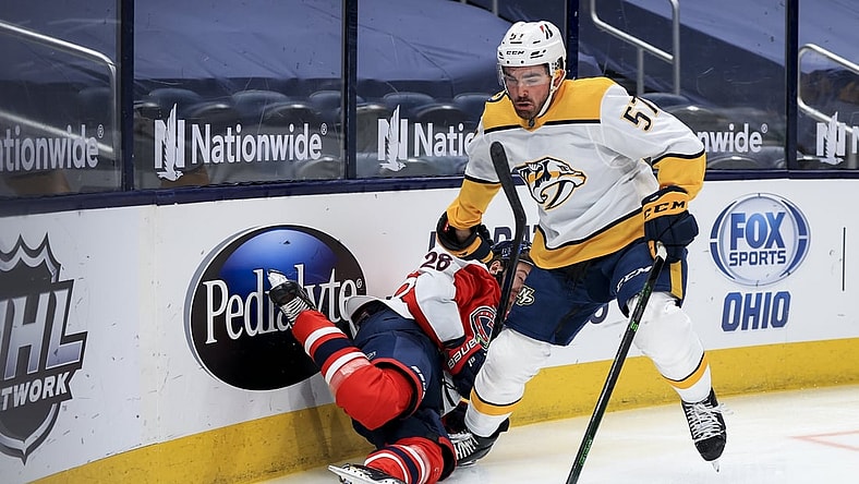 Feb 20, 2021; Columbus, Ohio, USA; Columbus Blue Jackets right wing Oliver Bjorkstrand (28) is checked by Nashville Predators defenseman Dante Fabbro (57) along the boards in the first period at Nationwide Arena. Mandatory Credit: Aaron Doster-USA TODAY Sports