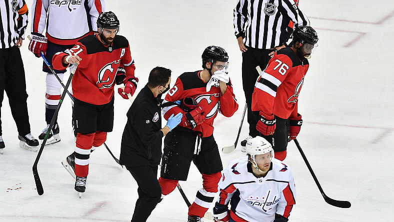 Feb 27, 2021; Newark, New Jersey, USA; New Jersey Devils center Nico Hischier (13) skates off the ice after being hit in the face during a game against the Washington Capitals during the third period at Prudential Center. Mandatory Credit: Catalina Fragoso-USA TODAY Sports