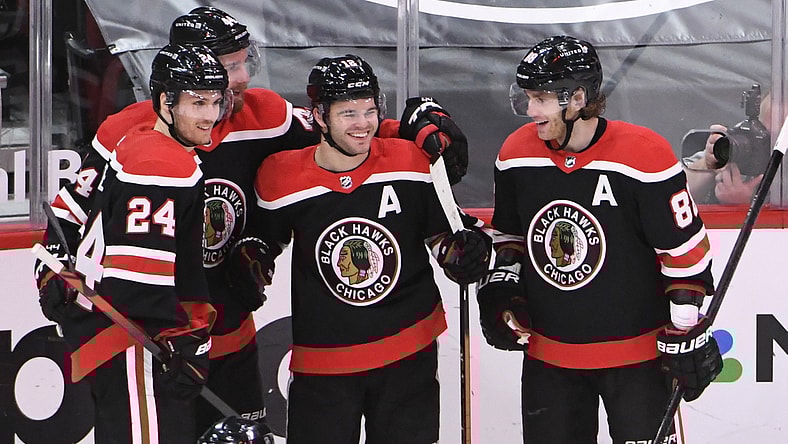 Feb 28, 2021; Chicago, Illinois, USA; Chicago Blackhawks left wing Alex DeBrincat (center)  celebrates his goal against the Detroit Red Wings during the third period at United Center. Mandatory Credit: David Banks-USA TODAY Sports