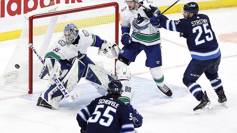 Mar 1, 2021; Winnipeg, Manitoba, CAN;  Vancouver Canucks defenseman Alexander Edler (23) defends against Winnipeg Jets center Paul Stastny (25) as goaltender Thatcher Demko (35) defends the goal in the third period at Bell MTS Place. Mandatory Credit: James Carey Lauder-USA TODAY Sports