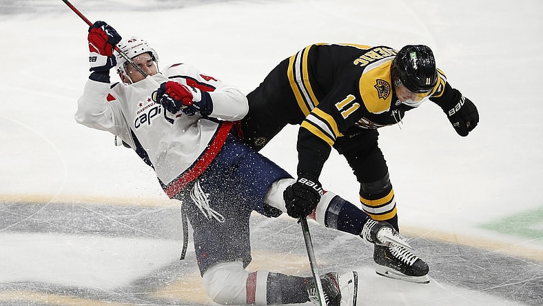 Mar 3, 2021; Boston, Massachusetts, USA; Boston Bruins center Trent Frederic (11) knocks down Washington Capitals right wing Tom Wilson (43) during the second period at TD Garden. Mandatory Credit: Winslow Townson-USA TODAY Sports