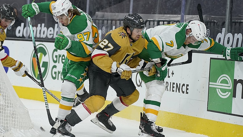 Mar 3, 2021; Las Vegas, Nevada, USA;  Minnesota Wild center Nico Sturm (7), Vegas Golden Knights defenseman Shea Theodore (27) and left wing Kirill Kaprizov (97) battle for the puck during the first period of an NHL hockey game Wednesday, March 3, 2021, in Las Vegas.  Mandatory Credit:  John Locher-POOL PHOTOS-USA TODAY Sports