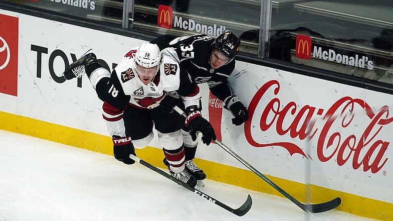 Mar 3, 2021; Los Angeles, California, USA; Arizona Coyotes center Christian Dvorak (18) and LA Kings defenseman Tobias Bjornfot (33) battle for the puck in the second period at Staples Center. Mandatory Credit: Kirby Lee-USA TODAY Sports