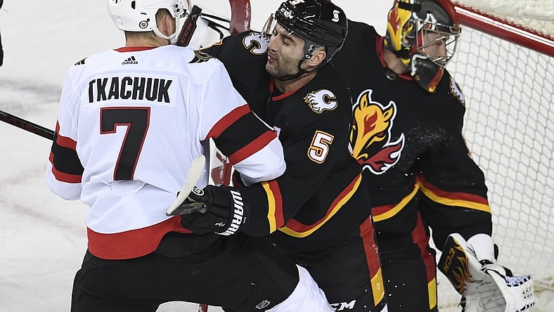 Mar 4, 2021; Calgary, Alberta, CAN; Ottawa Senators forward Brady Tkachuk (7) battles with Calgary Flames defenseman Mark Giordano (5) during the first period  at Scotiabank Saddledome. Mandatory Credit: Candice Ward-USA TODAY Sports