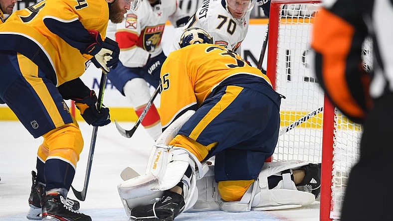 Mar 4, 2021; Nashville, Tennessee, USA; Nashville Predators defenseman Mattias Ekholm (14) watches as a shot by Florida Panthers right wing Patric Hornqvist (70) slides through the crease behind goaltender Pekka Rinne (35) during the second period at Bridgestone Arena. Mandatory Credit: Christopher Hanewinckel-USA TODAY Sports