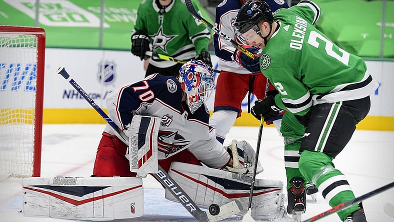 Mar 4, 2021; Dallas, Texas, USA; Columbus Blue Jackets goaltender Joonas Korpisalo (70) stops a shot by Dallas Stars defenseman Jamie Oleksiak (2) during the second period at the American Airlines Center. Mandatory Credit: Jerome Miron-USA TODAY Sports