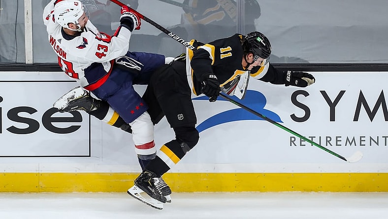 Mar 5, 2021; Boston, Massachusetts, USA; Washington Capitals right wing Tom Wilson (43) checks Boston Bruins center Trent Frederic (11) during the first period at TD Garden. Mandatory Credit: Paul Rutherford-USA TODAY Sports