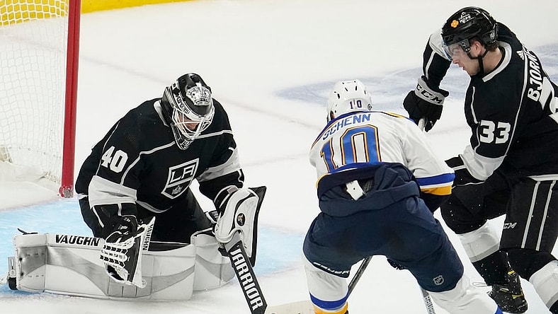 Mar 5, 2021; Los Angeles, California, USA; Los Angeles Kings goaltender Calvin Petersen (40) knocks the puck away from St. Louis Blues center Brayden Schenn (10) during the second period at Staples Center. At right is Los Angeles Kings defenseman Tobias Bjornfot (33). Mandatory Credit: Robert Hanashiro-USA TODAY Sports