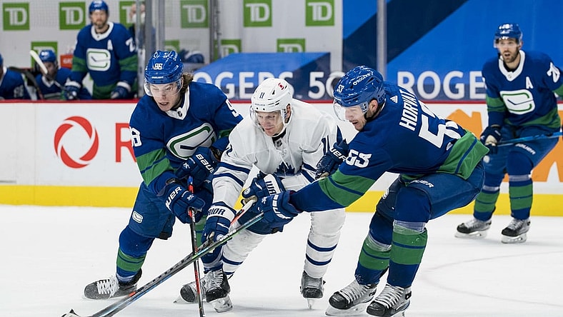 Mar 6, 2021; Vancouver, British Columbia, CAN; Vancouver Canucks forward Adam Gaudette (96) and  forward Bo Horvat (53) check Toronto Maple Leafs forward  Zach Hyman (11) in the third period at Rogers Arena. Canucks won 4-2. Mandatory Credit: Bob Frid-USA TODAY Sports