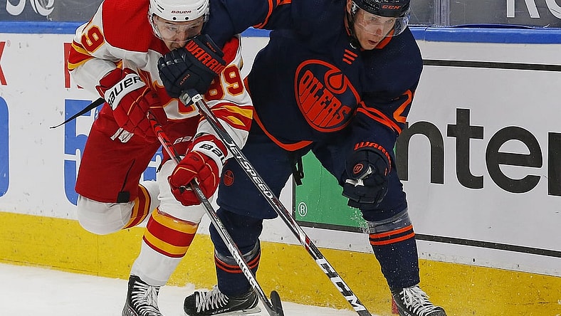 Mar 6, 2021; Edmonton, Alberta, CAN; Edmonton Oilers forward Dominik Kahun (21) and Calgary Flames defensemen Nikita Nesterov (89) battle for position during the first period at Rogers Place. Mandatory Credit: Perry Nelson-USA TODAY Sports