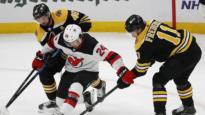 Mar 7, 2021; Boston, Massachusetts, USA; New Jersey Devils defenseman Ty Smith (24) tries to hold off Boston Bruins center Trent Frederic (11) and center David Krejci (46) during the first period at TD Garden. Mandatory Credit: Winslow Townson-USA TODAY Sports