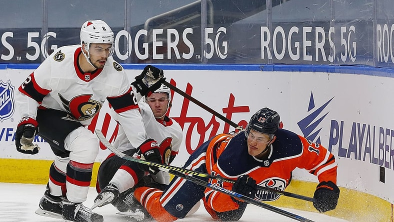 Mar 8, 2021; Edmonton, Alberta, CAN; Edmonton Oilers forward Jesse Puljujarvi (13) and Ottawa Senators defensemen Artem Zub (2) battle for a loose puck during the first period at Rogers Place. Mandatory Credit: Perry Nelson-USA TODAY Sports