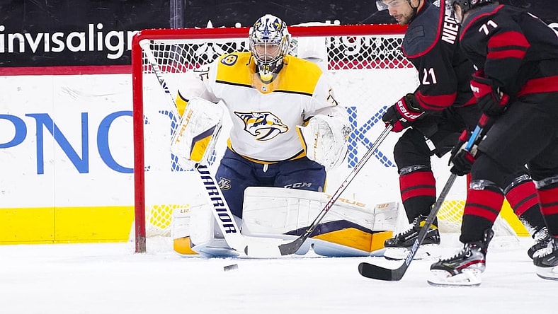 Mar 9, 2021; Raleigh, North Carolina, USA;  Carolina Hurricanes right wing Nino Niederreiter (21) gets ready to tip the shot on Nashville Predators goaltender Pekka Rinne (35) during the first period at PNC Arena. Mandatory Credit: James Guillory-USA TODAY Sports