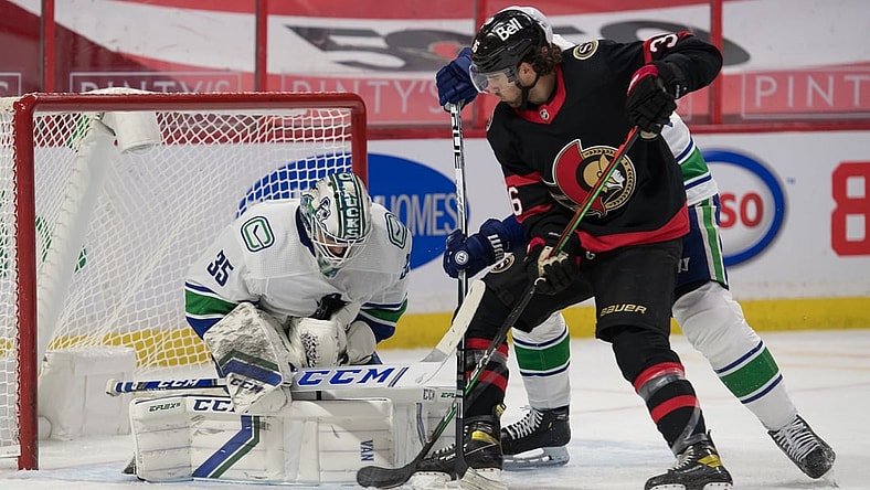 Mar 15, 2021; Ottawa, Ontario, CAN; Vancouver Canucks goalie Thatcher Demko (35) makes a save in front of Ottawa Senators center Colin White (36) in the second period at the Canadian Tire Centre. Mandatory Credit: Marc DesRosiers-USA TODAY Sports